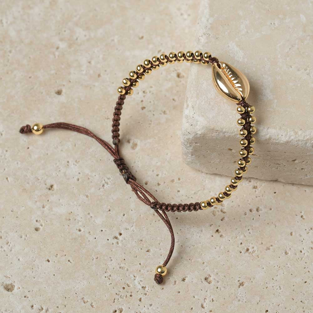 Bracciale intrecciato con conchiglia kauri oro espresso