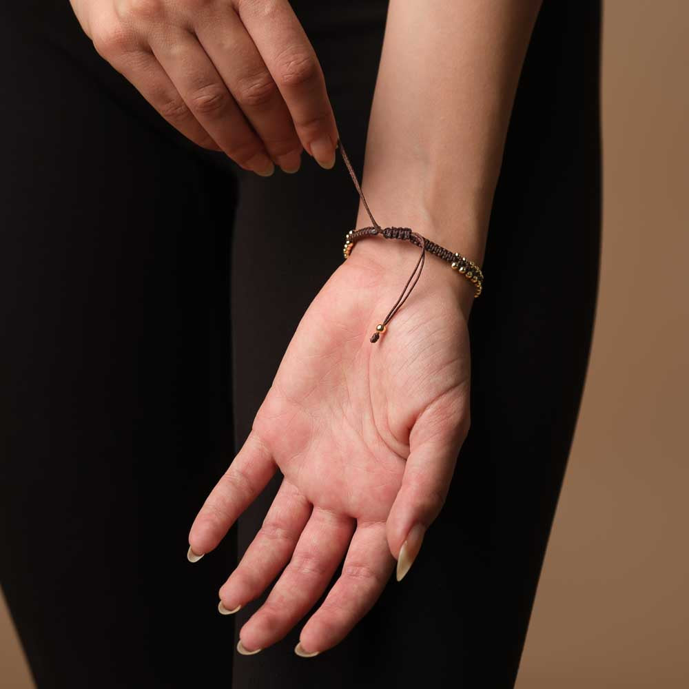 Bracciale intrecciato con conchiglia kauri oro espresso