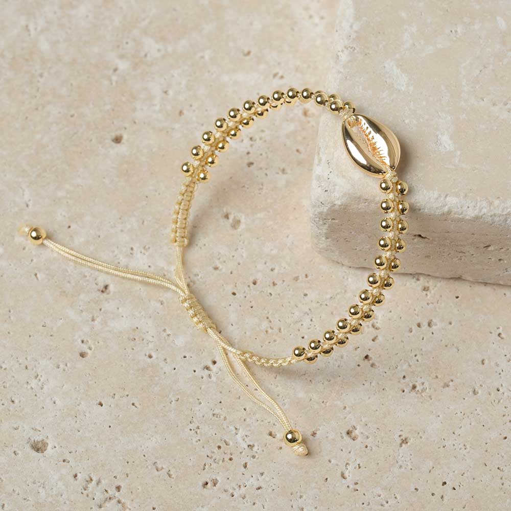 Bracciale intrecciato con conchiglia kauri e sabbia dorata