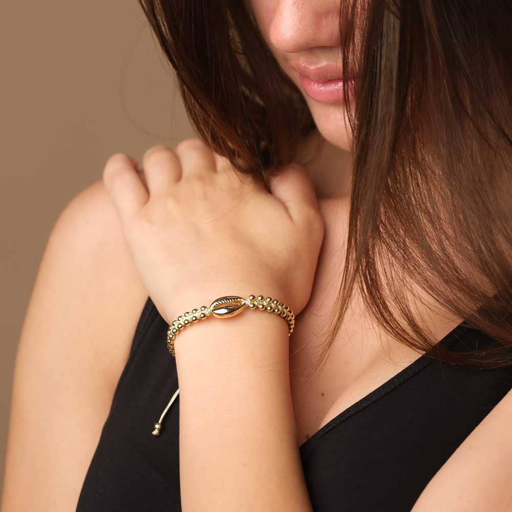 Bracciale intrecciato con conchiglia kauri e sabbia dorata
